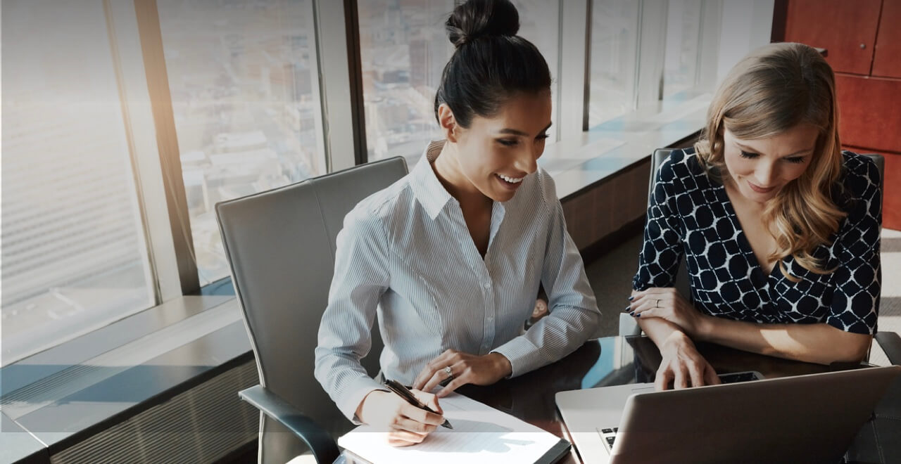 two women looking into a computer